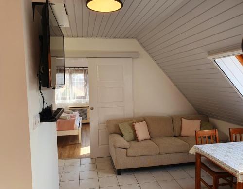 a living room with a couch and a table at Lavendel apartments in Hévíz