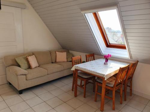 a living room with a table and a couch at Lavendel apartments in Hévíz