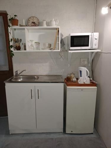 uma cozinha com um lavatório e um micro-ondas em 19 on Robyn em Durbanville