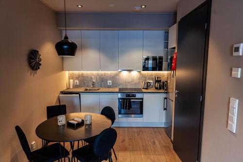 Il comprend une cuisine équipée d'une table et de chaises. dans l'établissement Levi Platinum Superior Apartments, à Levi