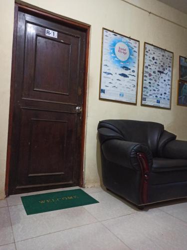 a black leather couch sitting next to a door at Seaface Rest Homestay in Hambantota