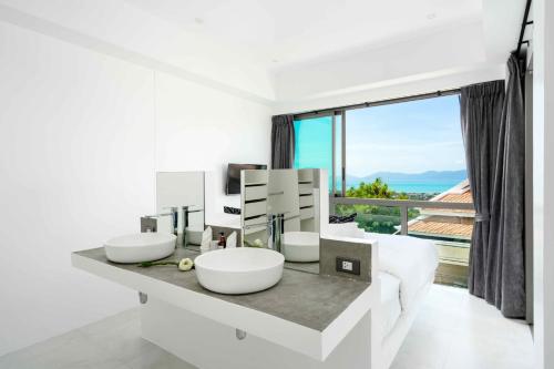 a white bathroom with two sinks and a large window at Best View Apartment in Koh Samui 