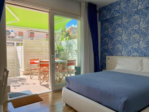 a bedroom with a bed and a balcony with a table at B&B Villa Pini in Civitanova Marche