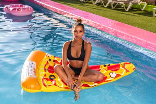 a woman in a bikini sitting on a raft in a pool at Now Benidorm in Benidorm