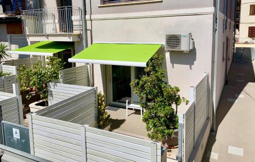a building with a green awning next to a building at B&B Villa Pini in Civitanova Marche