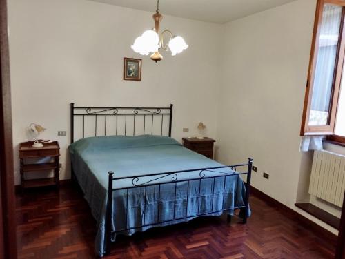 a bedroom with a bed and a chandelier at Casa Vacanze Corso Amendola in Bevagna