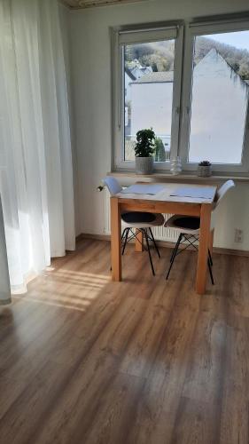 a room with a wooden table and two windows at Pension Schneider in Cochem