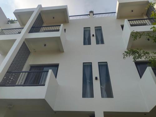 a white building with windows and balconies at H&M Boutique in Kampot