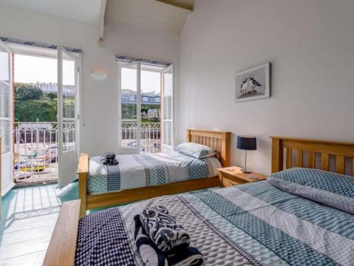 a bedroom with two beds and a balcony at Ultimate Harbourside in Ilfracombe