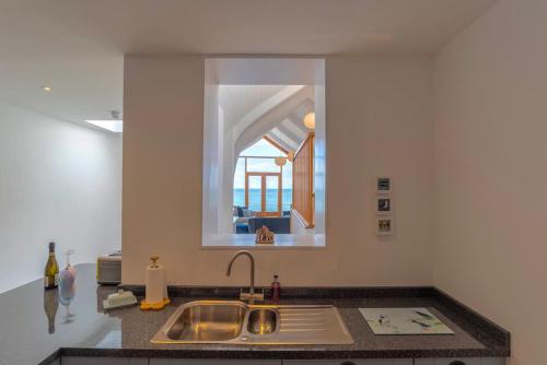 a kitchen with a sink and a mirror at Ultimate Harbourside in Ilfracombe
