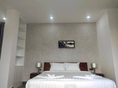 H&M Boutique في كامبوت: غرفة نوم عليها سرير وفوط بيضاء