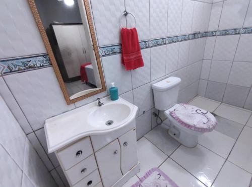 Baño blanco con lavabo y aseo en Casa individual aconchegante - Rio da praia - Bertioga, en Bertioga