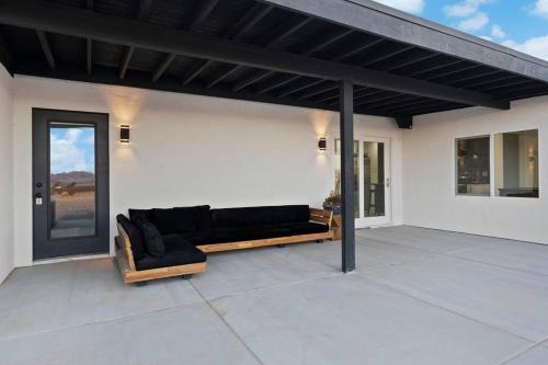a patio with a black couch on a white wall at Star gazers with pool modern home on 5 acres! in Sunfair Heights