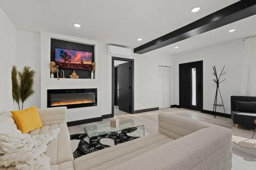 a living room with a couch and a fireplace at Star gazers with pool modern home on 5 acres! in Sunfair Heights