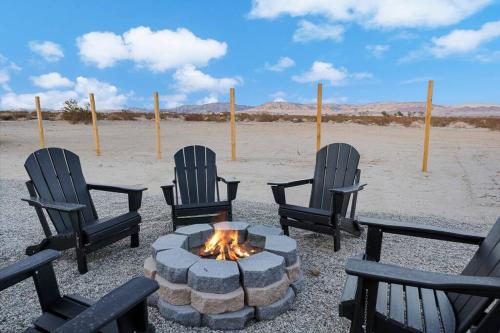 a group of chairs around a fire pit in the desert at Star gazers with pool modern home on 5 acres! in Sunfair Heights