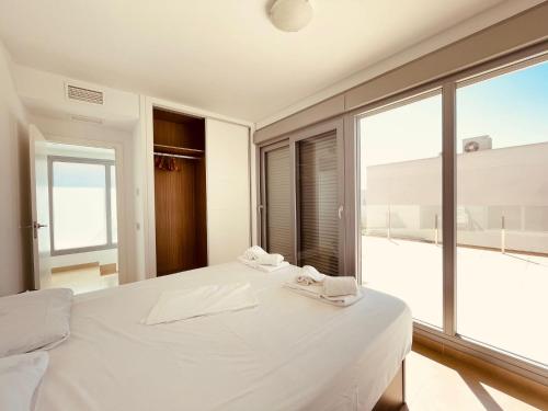 1 dormitorio con 1 cama blanca grande y ventana grande en 3053 Malibu, en Orihuela
