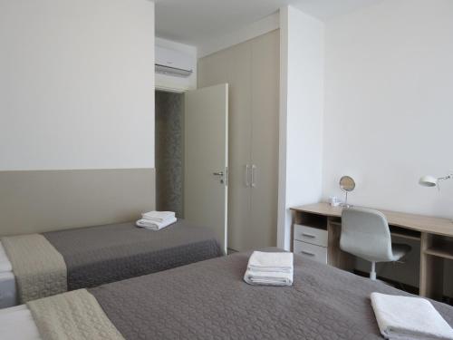 ein Hotelzimmer mit 2 Betten, einem Schreibtisch und einem Stuhl in der Unterkunft Premium NB Apartment - Belgrade Waterfront in Belgrad