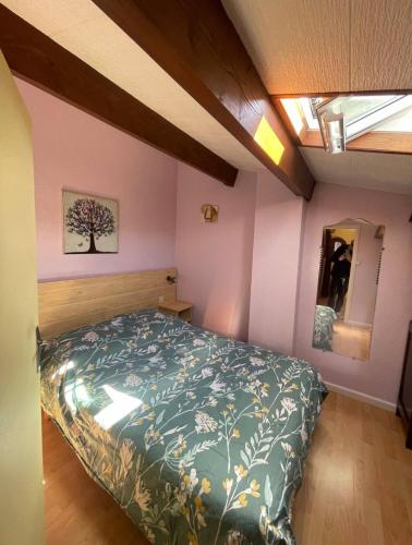 1 dormitorio con 1 cama con edredón verde en Charmante Villa de vacances en Cap d'Agde