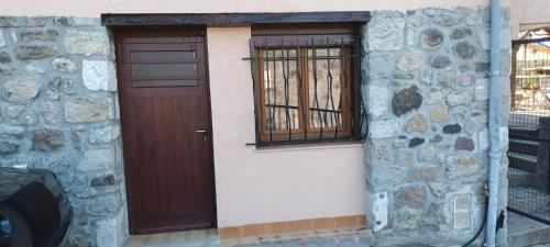 a building with a brown door and a window at Le Panorama - Panoramic mountain view - very very quiet in Saint-Antonin