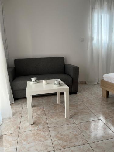 a living room with a couch and a white coffee table at G.S Ialysos Holiday Apartment in Ialyssos