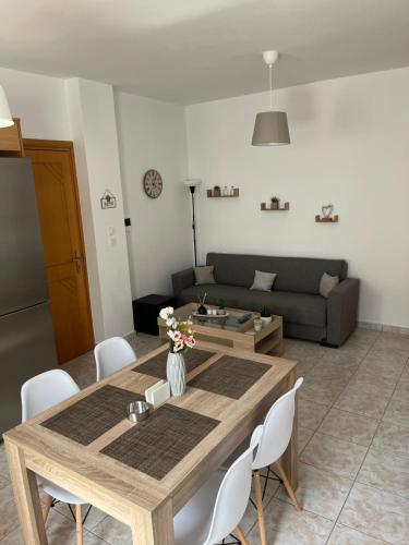 a living room with a wooden table and a couch at G.S Ialysos Holiday Apartment in Ialyssos