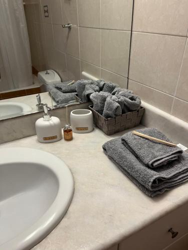 a bathroom with a sink and a counter with towels at G.S Ialysos Holiday Apartment in Ialyssos