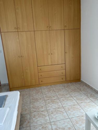 a room with wooden cabinets and a tiled floor at G.S Ialysos Holiday Apartment in Ialyssos