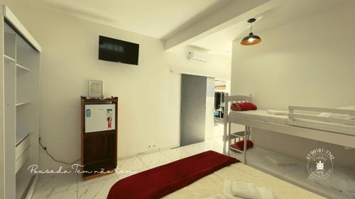 ein Krankenhauszimmer mit einem Bett und einem TV an der Wand in der Unterkunft Pousada Tem não tem, Parque Beto Carrero, Penha, SC in Penha