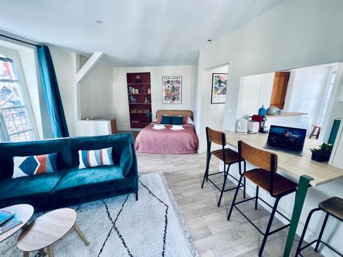 - un salon avec un canapé, une table et un lit dans l'établissement Studio Remigny, hyper centre ville de Nevers, style "Appart-hôtel" by PRIMO C0NCIERGERIE, à Nevers