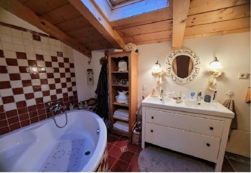 a bathroom with a tub and a sink and a mirror at Haus Markus in Wolfsberg