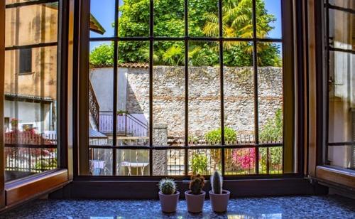 a room with a large window with potted plants at Il Monastero in Castelletto sopra Ticino