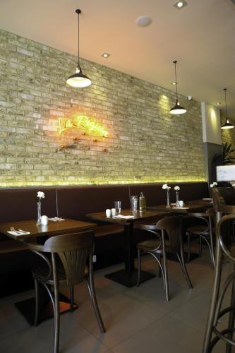 a restaurant with wooden tables and a brick wall at Kings Cross Inn Hotel in London