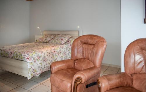 - une chambre avec un lit et un fauteuil en cuir dans l'établissement Cozy Home In Quemperven With Wifi, à Quemperven