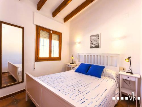 1 dormitorio con 1 cama grande con almohadas azules en VH CostaBlanca - OSALVA, en Benissa