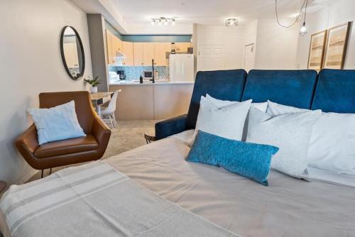 a bedroom with a bed with blue pillows and a chair at Gorgeous Condo, Perfect Okanagan Getaway 1207 in Kelowna