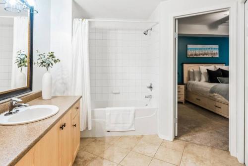 łazienka z umywalką, wanną i łóżkiem w obiekcie Gorgeous Condo, Perfect Okanagan Getaway 1207 w mieście Kelowna