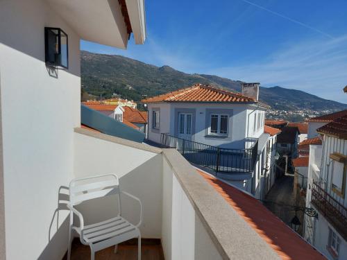 a white chair sitting on the balcony of a building at Ritta´s House - Covilhã in Covilhã