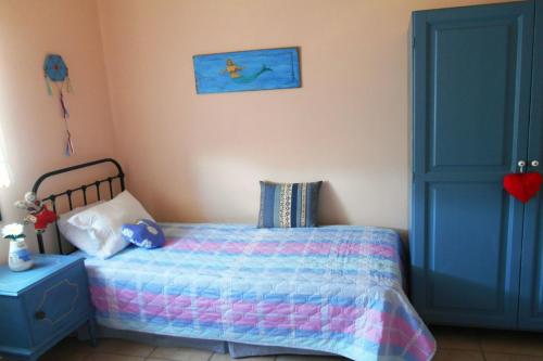 a childs bedroom with a bed and a blue door at Polytropon Apartments in Kástron
