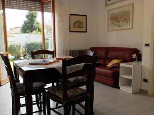 a living room with a table and chairs and a couch at Appartamento con giardino a 5 minuti dal mare in Torre del Lago Puccini