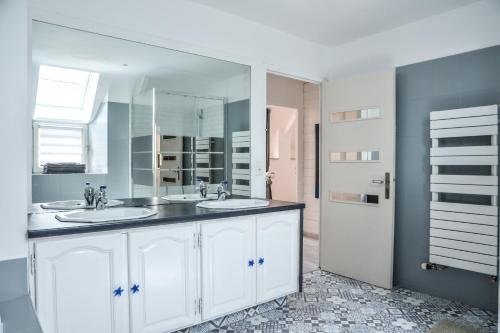 une salle de bain avec deux lavabos et un grand miroir dans l'établissement VILLA KER BLEUENN * 10 PERSONNES * PISCINE * SAUNA, à La Fresnais