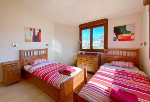 a bedroom with two beds and a window at Ampuriahome Villa hosting 15, pool & mooring in Empuriabrava