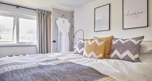 una camera da letto con un letto e un vestito appeso a una finestra di East End Cottage a Logierait