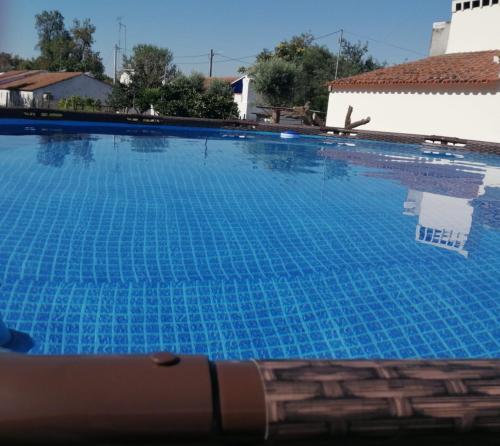 a large swimming pool with blue water at Casa da Venda do Ferrador in Estremoz