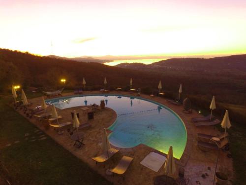 a large swimming pool with chairs and umbrellas at EcoResort Il Cantico della Natura in Magione