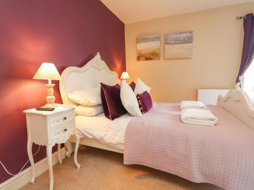 a bedroom with a bed and a table with lamps at 21 West View in Clitheroe