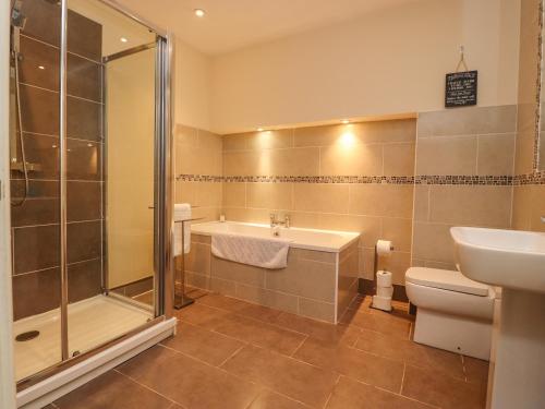 a bathroom with a shower and a sink and a toilet at 21 West View in Clitheroe