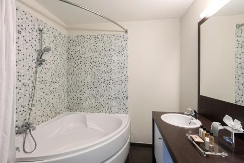 Dukes' Apartments Grand Place في بروج: حمام أبيض مع حوض ومغسلة