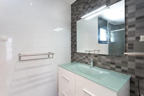 a bathroom with a sink and a mirror at 5 bedrooms villa with private pool enclosed garden and wifi at Lloret de Mar 1 km away from the beach in Lloret de Mar