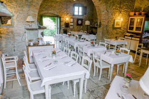 a dining room with white tables and white chairs at EcoResort Il Cantico della Natura in Magione