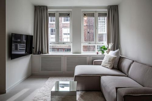 a living room with a couch and a window at Cloud Nine - romantic & design app in city center! in Dordrecht